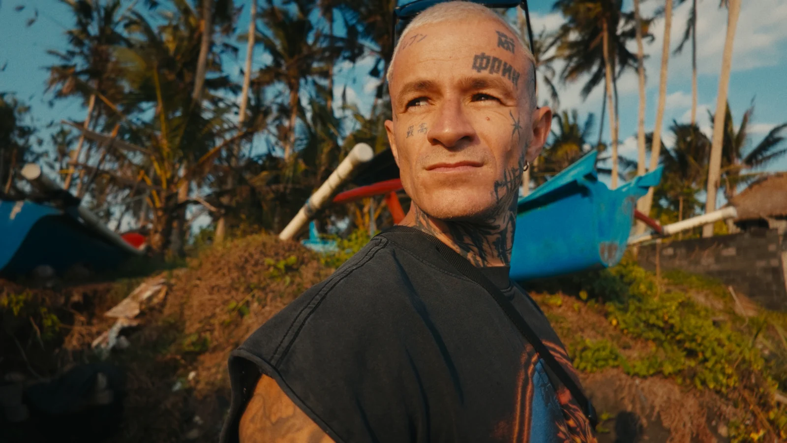 Charly, filmmaker, in front of palm trees